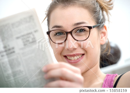 young and smiling woman with glasses, reading young and smiling woman with glasses, reading 53858159