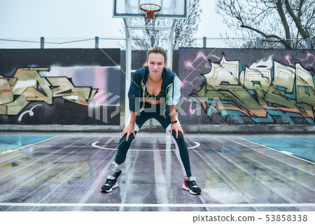Be stronger. Young healthy disabled woman is standing on stadium and looking at camera while doing Be stronger. Young healthy disabled woman is standing on stadium and looking at camera while doing 53858338