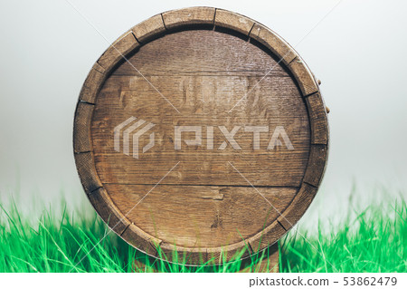 Old woden barrel in grass on a gray background. Old woden barrel in grass on a gray background. 53862479