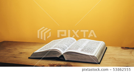 Bible on a brown wooden table. Beutiful orange 53862555