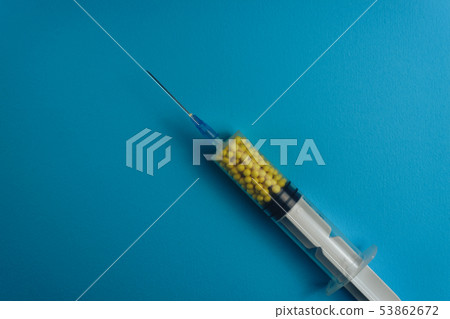 Syringe filled with colorful nano balls on a blue Syringe filled with colorful nano balls on a blue 53862672