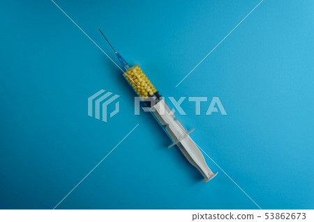 Syringe filled with colorful nano balls on a blue 53862673