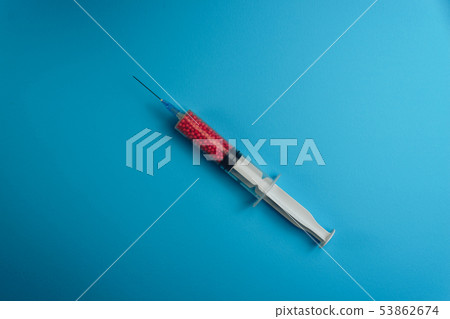 Syringe filled with colorful nano balls on a blue 53862674