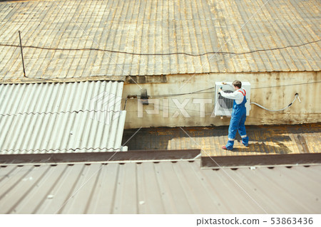 HVAC technician working on a capacitor part for condensing unit HVAC technician working on a capacitor part for condensing unit 53863436