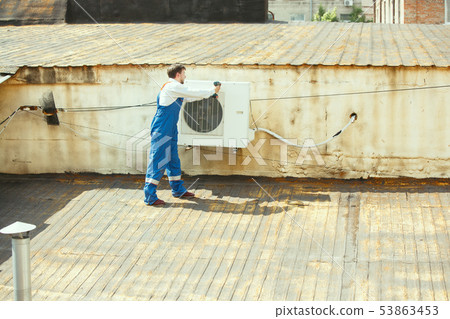 HVAC technician working on a capacitor part for condensing unit HVAC technician working on a capacitor part for condensing unit 53863453