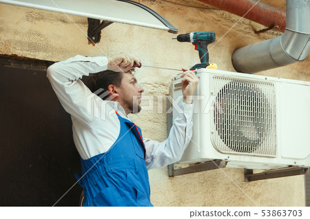 HVAC technician working on a capacitor part for condensing unit 53863703