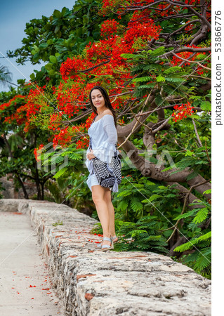 Beautiful woman on white dress walking alone at 53866776