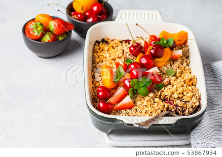 Fruits and berries oat crumble in oven dish  53867934