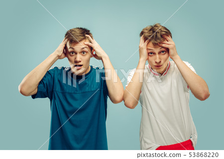 Two young men isolated on blue background 53868220