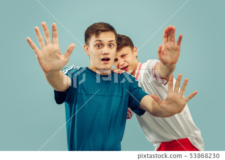 Two young men isolated on blue background 53868230