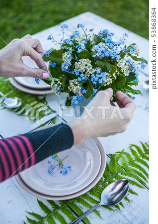 Top view florist makes a bouquet of forget-me-not 53868364