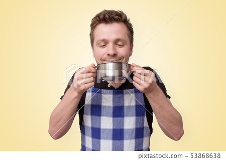 Mature caucasian man holding a pan with tasty meal Mature caucasian man holding a pan with tasty meal 53868638