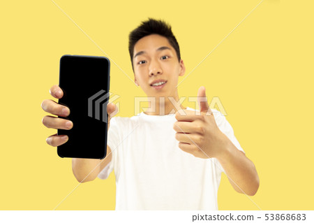Korean young man's half-length portrait on yellow background Korean young man's half-length portrait on yellow background 53868683