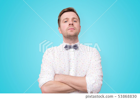 young man in white shirt standing with arms 53868830