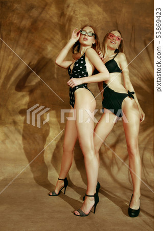 Beautiful girls isolated on braun studio background Beautiful girls isolated on braun studio background 53869423