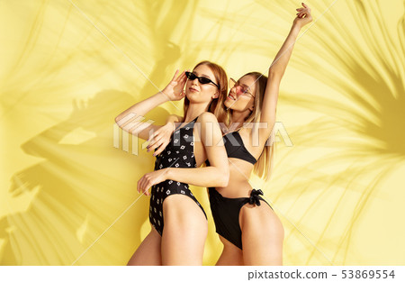 Beautiful girls isolated on yellow studio background 53869554