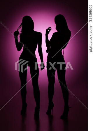 Full-length female silhouettes on purple background Full-length female silhouettes on purple background 53869602