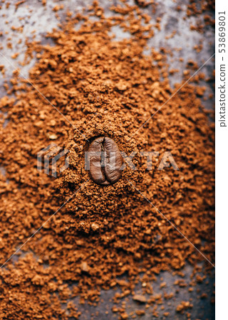 Coffee bean on heap of grinded coffee Coffee bean on heap of grinded coffee 53869801