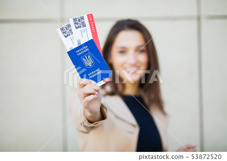 Travel. Woman holding two air ticket in abroad passport near airport Travel. Woman holding two air ticket in abroad passport near airport 53872520