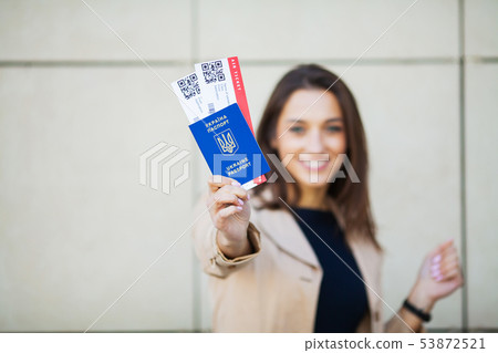 Travel. Woman holding two air ticket in abroad passport near airport Travel. Woman holding two air ticket in abroad passport near airport 53872521