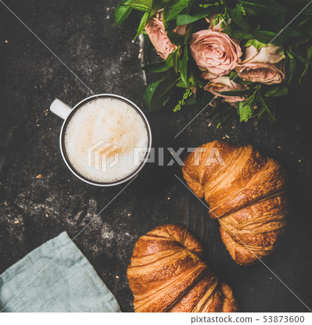 Cup of cappuccino, fresh croissants and flowers 53873600