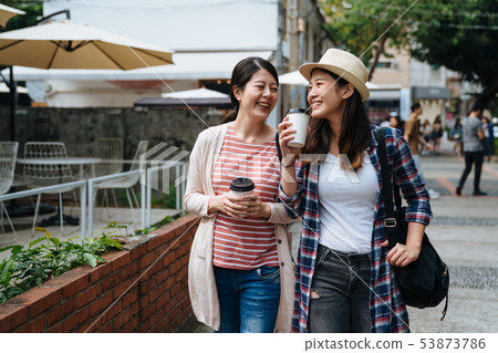 happy girls talking and carry coffee to go 53873786