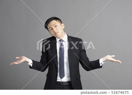 confused young businessman shrugging shoulders confused young businessman shrugging shoulders 53874675