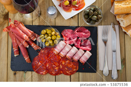 Top view of sliced gammon, chorizo, salami, bacon on slate board Top view of sliced gammon, chorizo, salami, bacon on slate board 53875536