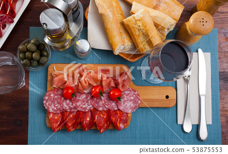 Spanish tasty meal slicing sausages and jamon with tomatoes, close up 53875553