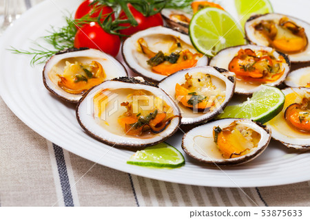 Baked in oven with sauce dog cockle with lemon and fresh greens 53875633