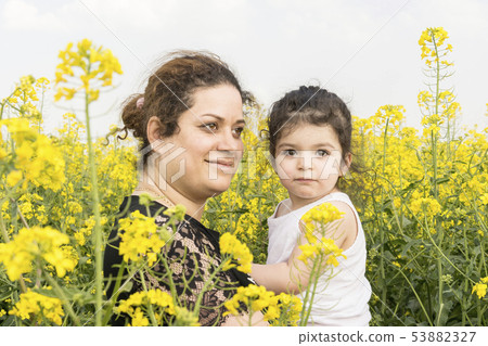 Portrait of a young happy mother embraced her 53882327