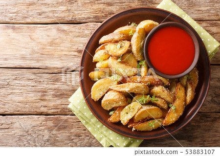 Fried potato wedges with parmesan and herbs with 53883107