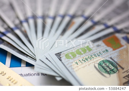 Huge pack of US money and bank card lying down on important financial document Huge pack of US money and bank card lying down on important financial document 53884247
