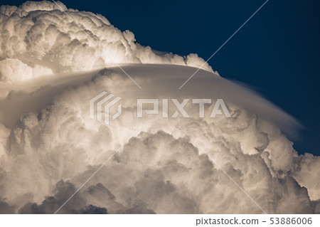 Rare Lenticular cloud Altocumulus lenticularis on top of a cumulus cloud in front of a blue sky 53886006