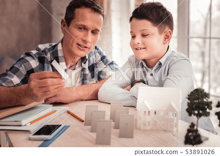 Foster father and his cute son building model of smart city 53891026