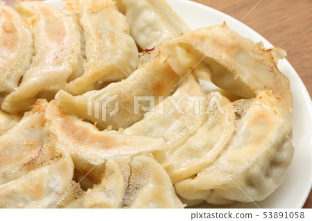 將大量烤餃子放在圓盤中，烤面朝上。 53891058