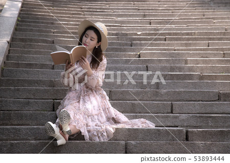 A woman reading a book A woman reading a book 53893444