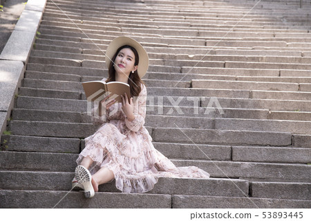 A woman reading a book A woman reading a book 53893445