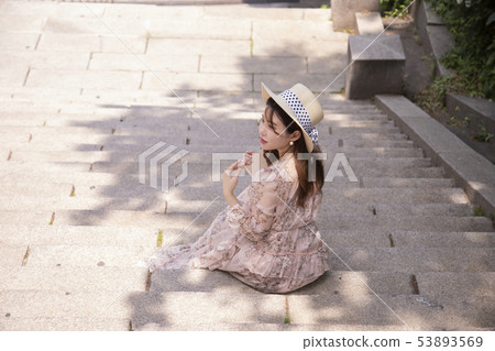 A woman sitting on the stairs and reading A woman sitting on the stairs and reading 53893569