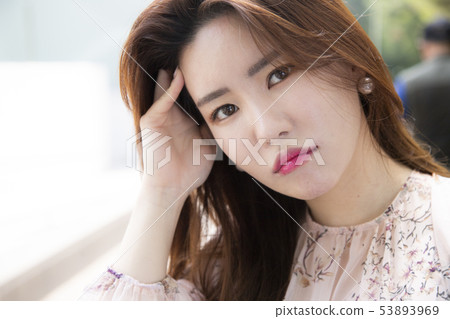 A woman touching her head 53893969