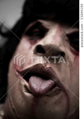 scary disfigured man sticking his tongue out 53894199