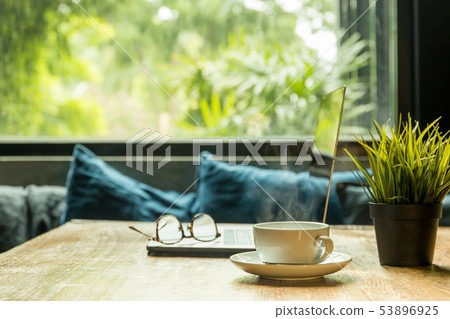 Business concept coffee cup with laptop and eyeglasses on wooden table. 53896925