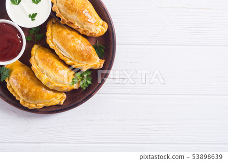 Latin American baked beef empanadas with sauce 53898639