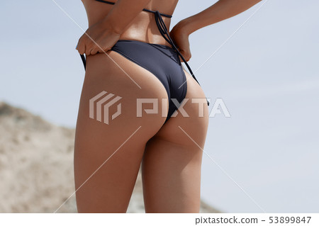Crop woman in swimwear touching buttocks Crop woman in swimwear touching buttocks 53899847