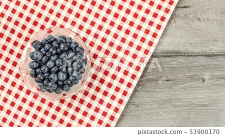 Tabletop view -  small bowl of blueberries, with 53900170