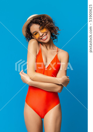 Cheerful black lady in swimsuit smiling on blue studio background 53900625