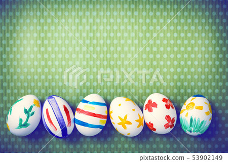 Painted Easter eggs on a green background with white polka dots Painted Easter eggs on a green background with white polka dots 53902149