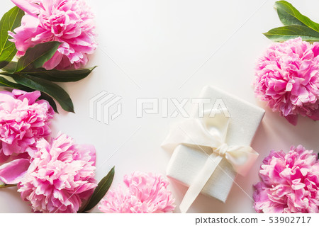 Bouquet of pink peony in vase with gift on white. Bouquet of pink peony in vase with gift on white. 53902717