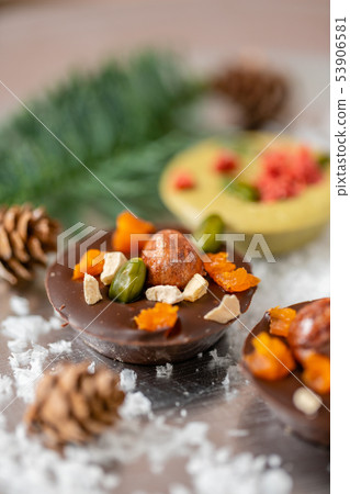 Christmas theme. Handmade chocolates candy. Mini chocolate dessert covered with nuts and dried 53906581