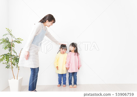 Children comparing their heights Children comparing their heights 53906759